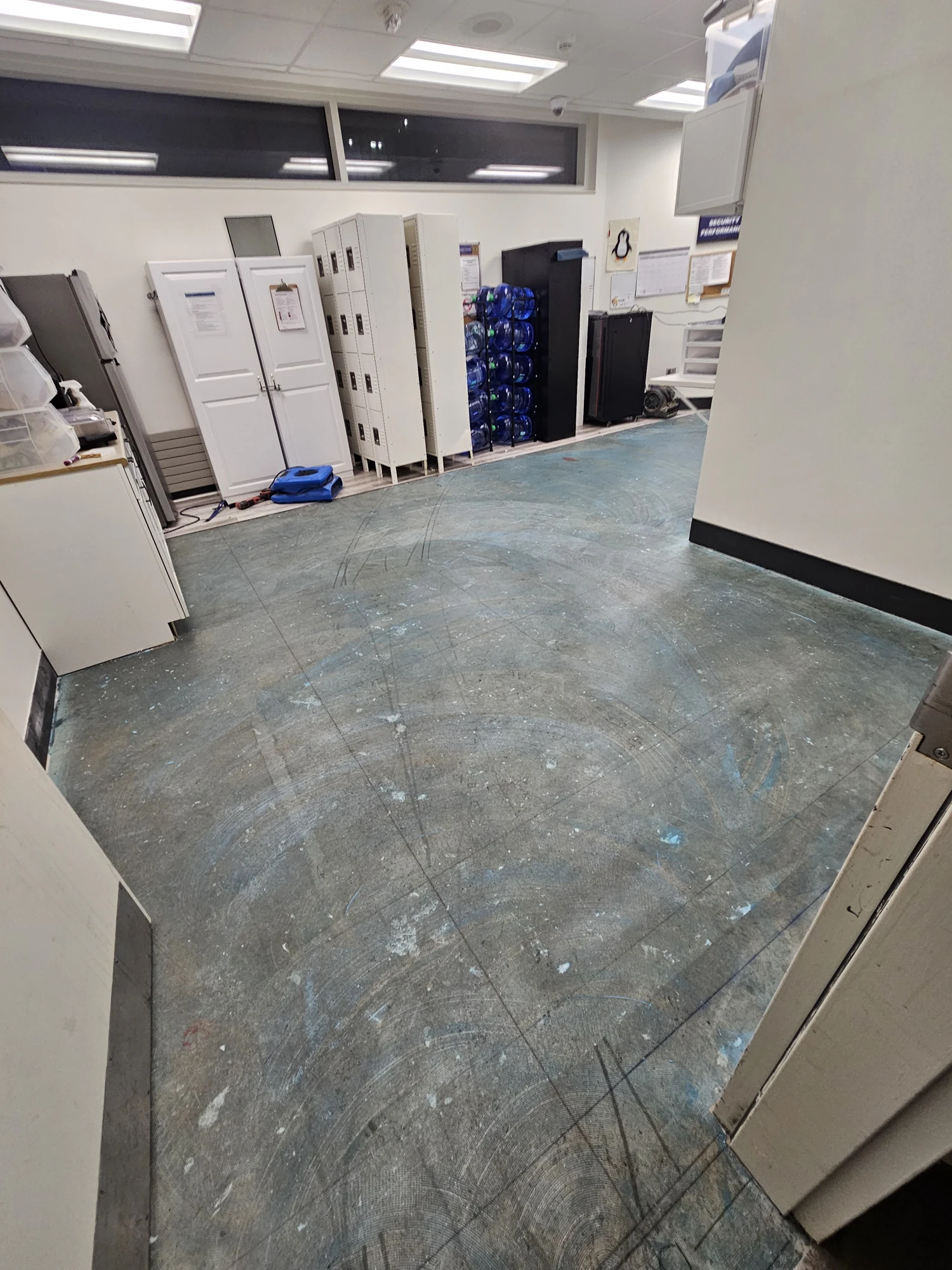 Office room before flooring installation, with the existing blue floor exposed