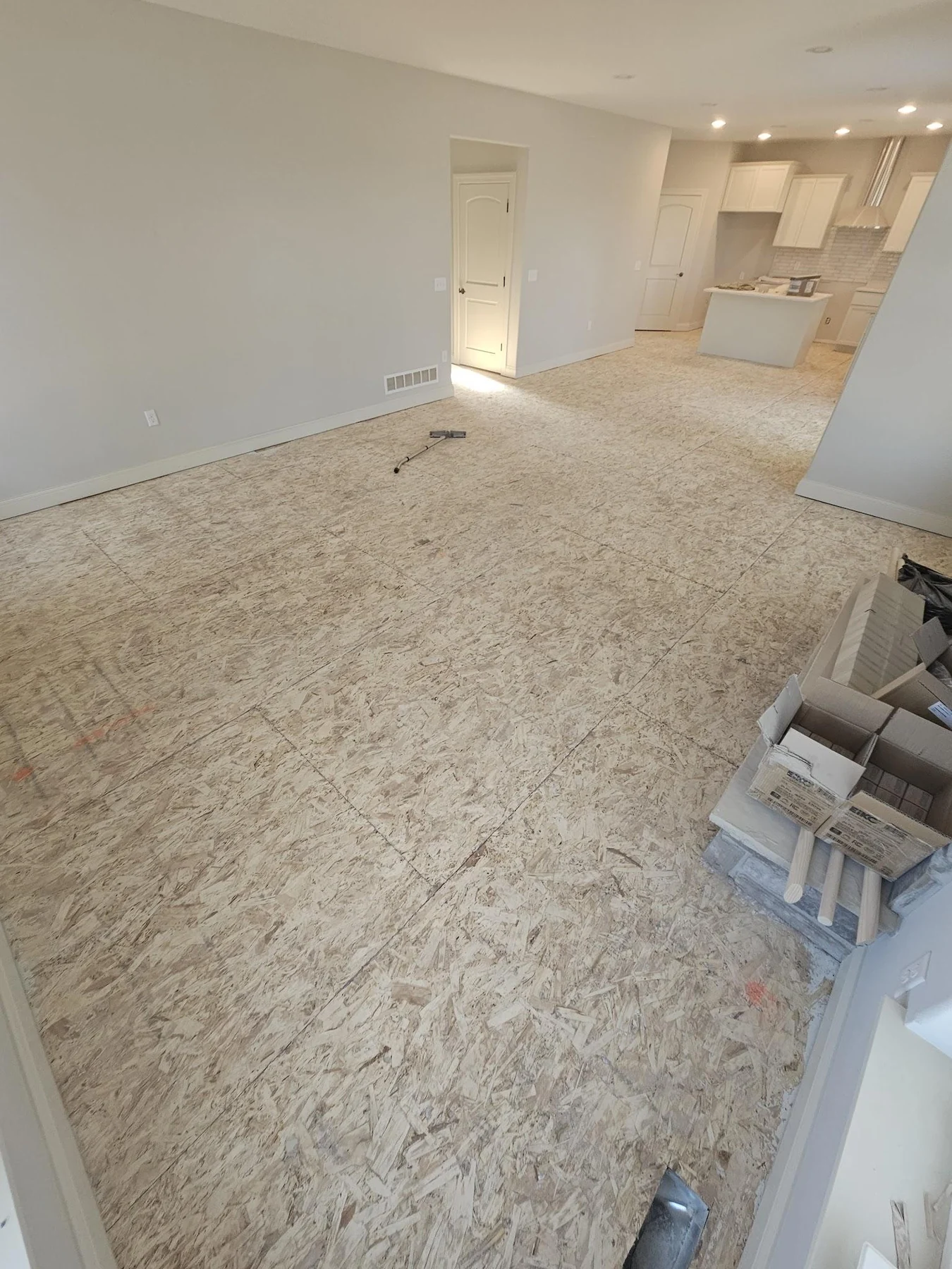 Exposed wood subfloor across a bright open room before flooring installation